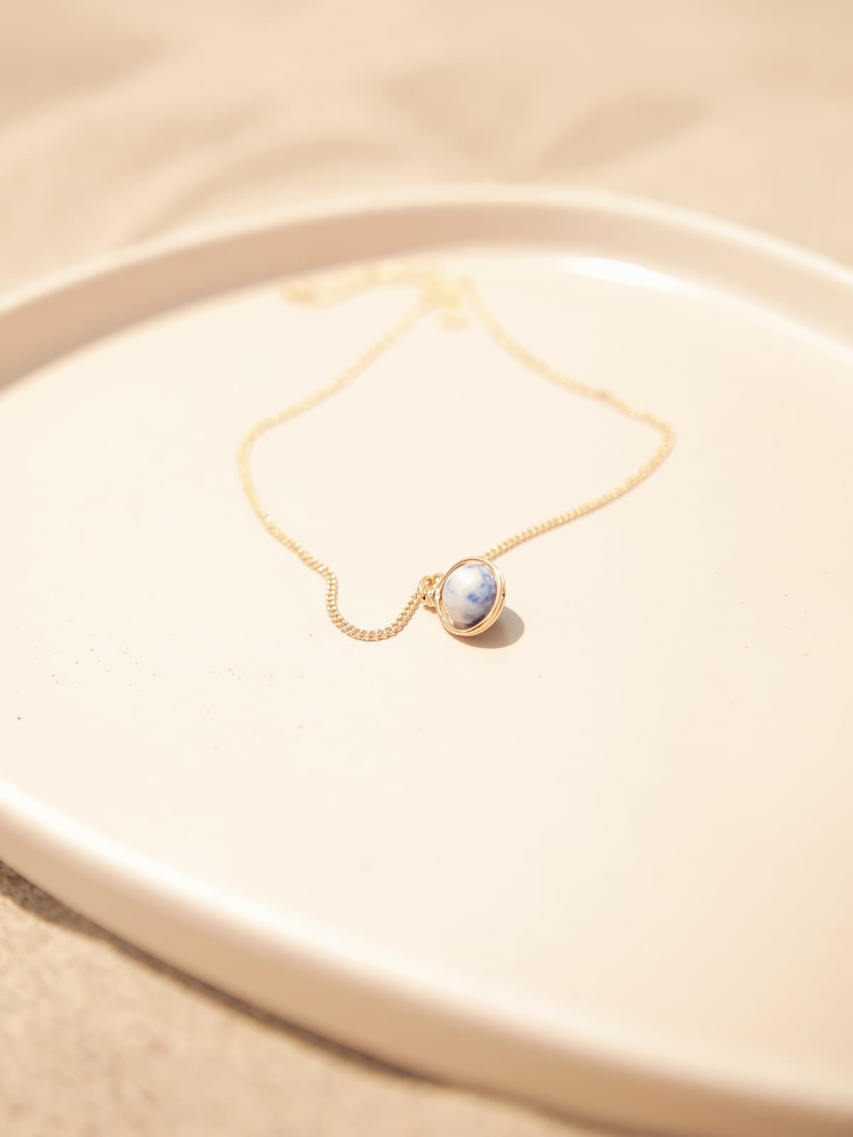 World Necklace - a gold necklace with a pendant